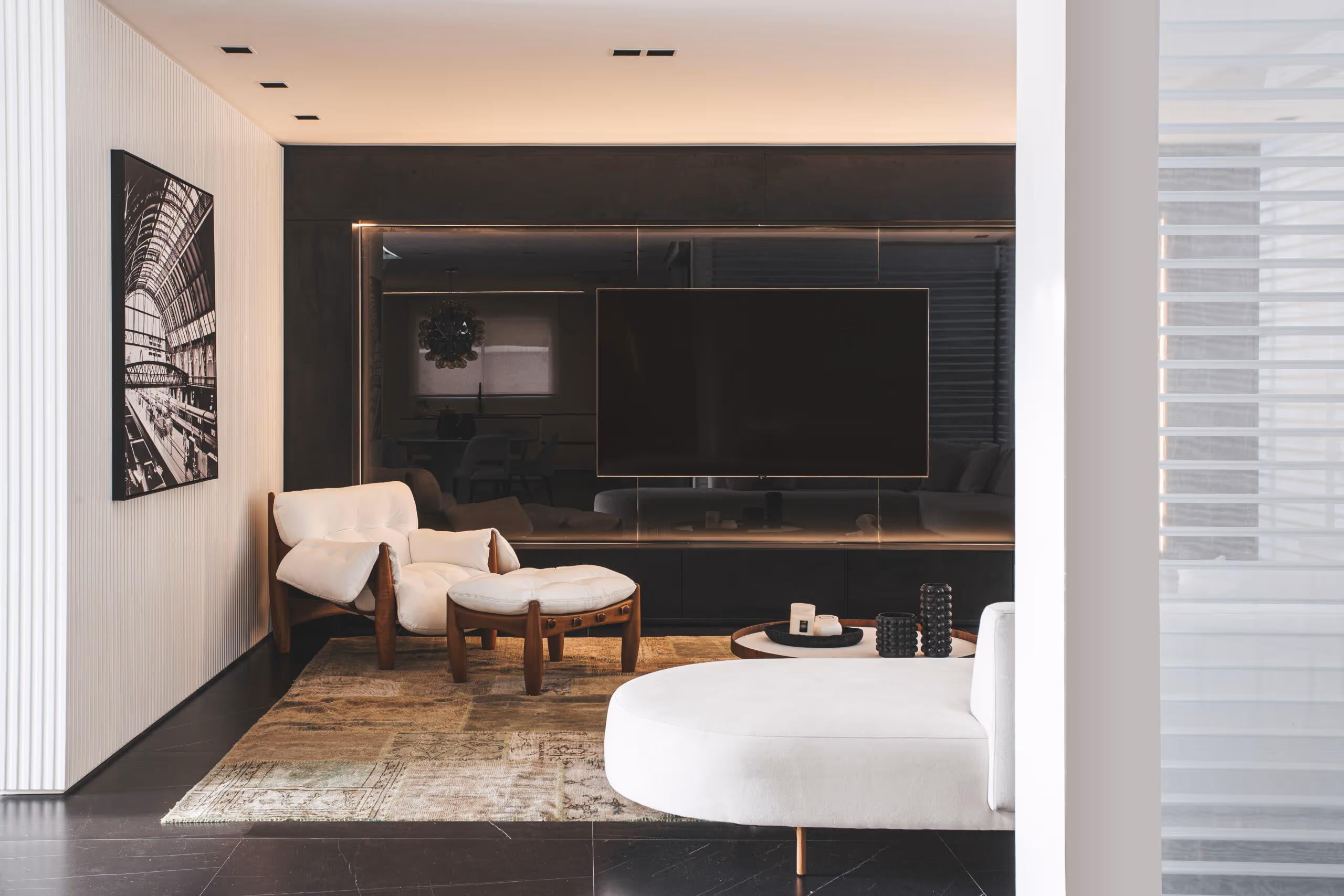Sala de estar planejada de alto padrão com painel de madeira e estante iluminada, projeto Bentec Curitiba